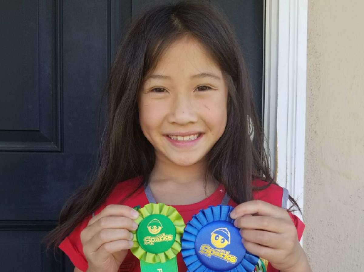 Katie, an Awana kid, with her club award ribbons